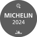 The image shows a gray circle with the text "MICHELIN 2024" and a small Michelin Man logo at the bottom, along with a star symbol.