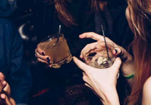 People are enjoying drinks and laughing in what appears to be a social or party setting.