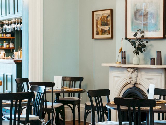 A dining area with a fireplace and tables set for guests.