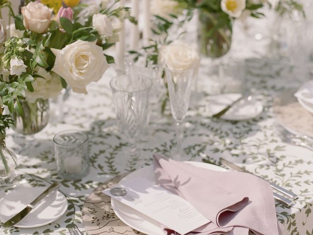 A formal table setting with a floral arrangement, glasses, plates, and silverware