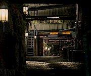 A dim alley tunnel shows the “Frosty Frog Express” sign overhead with “No vehicles beyond this point” and “Stairway ahead” warnings.