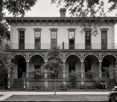 A two-story building with a balcony and arches